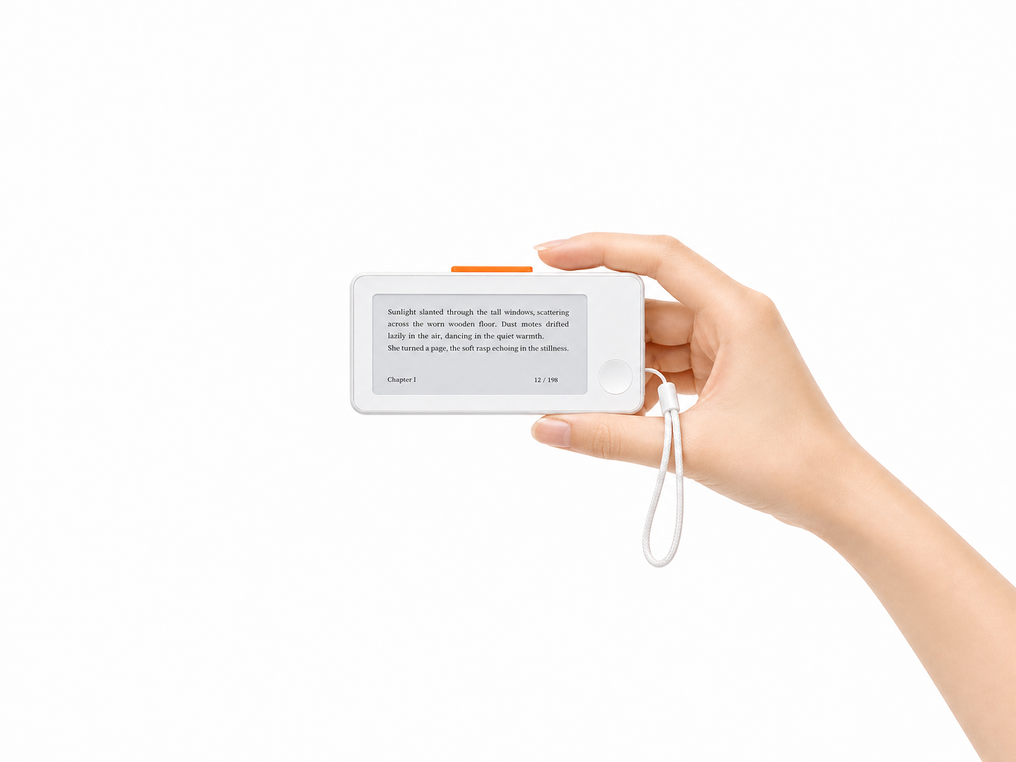 A small white e-ink reader with an orange top button and wrist strap on an everyday carry desk setup.